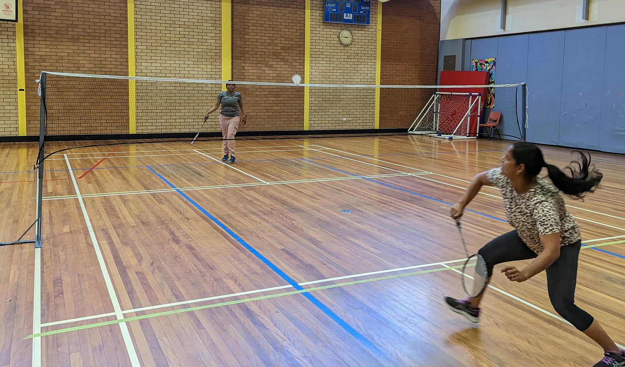 Two girls playing social Badminton