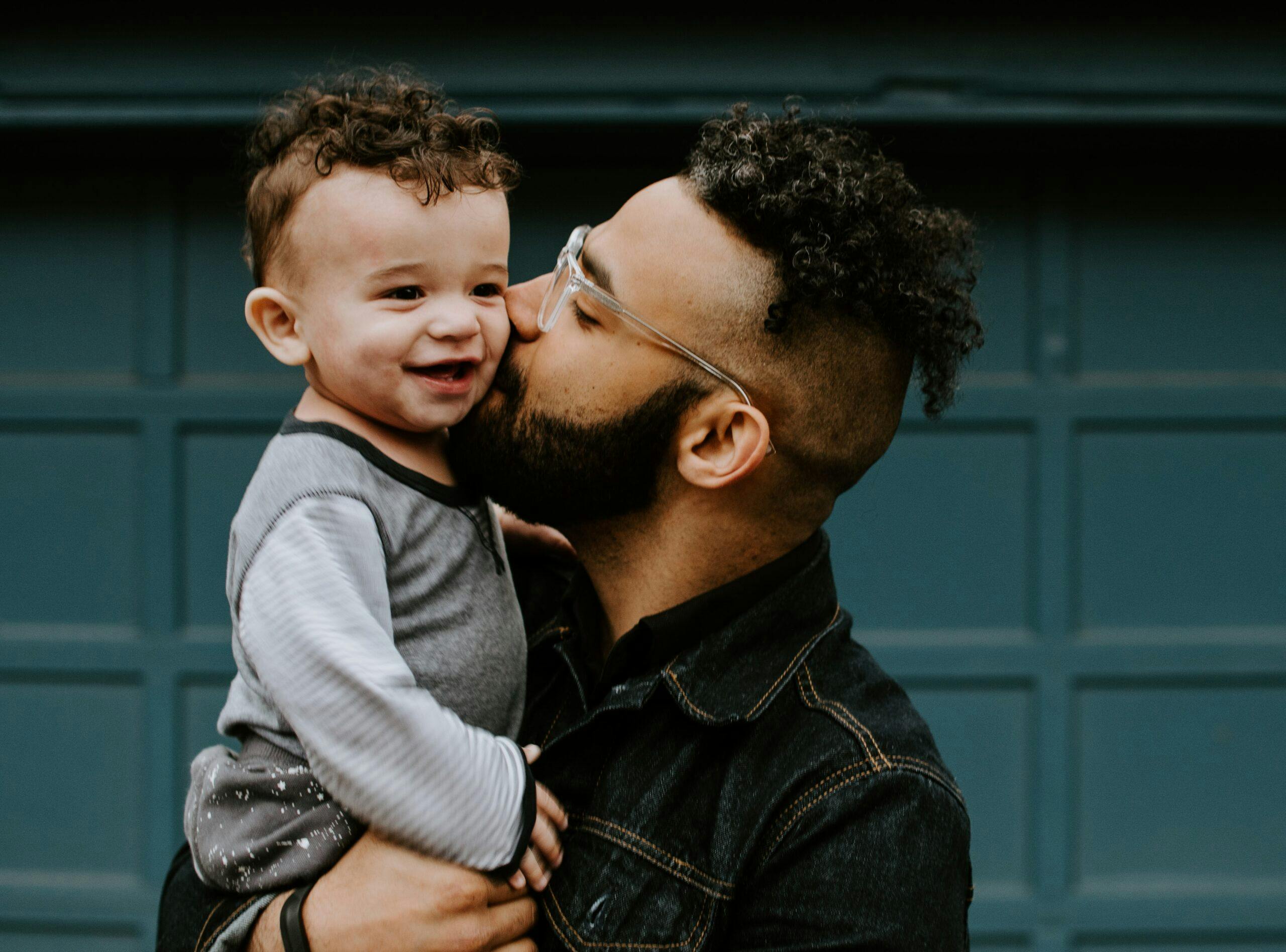 A man kissing his child on the cheek