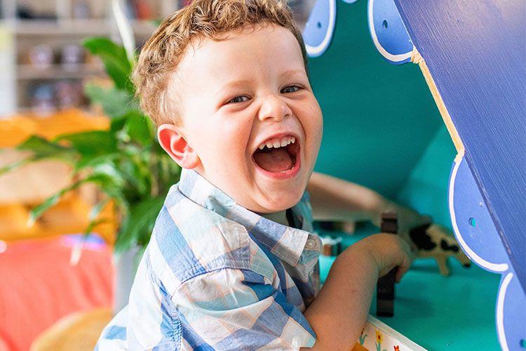 Boy playing with Dollhouse