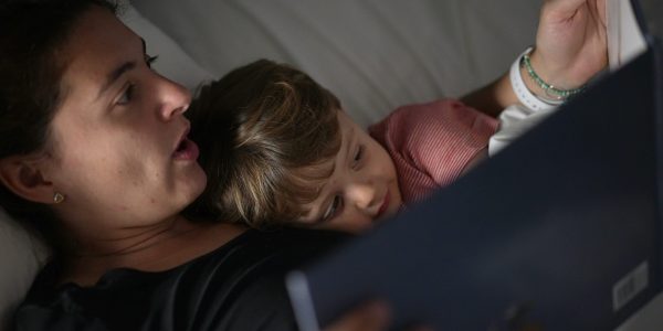 Mother telling bedtime story to toddler mom holding book night routine