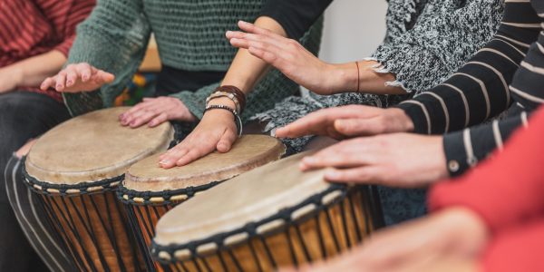 Group of people playing drums during a music therapy lessons, jembe drum, drumming concept Group of people playing drums during music therapy lessons, jembe drum, drumming concept